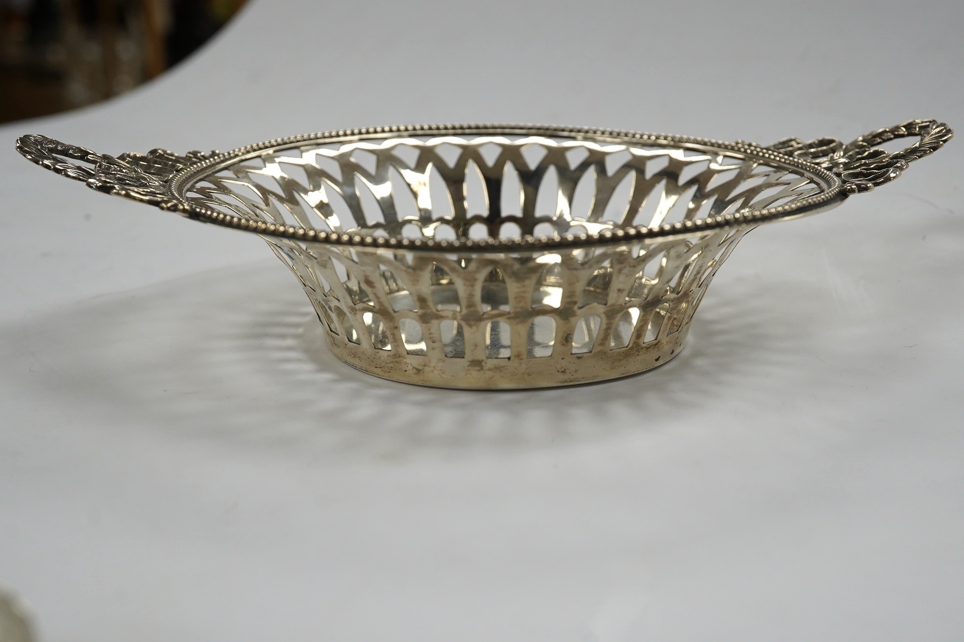 Two pairs of 19th century silver sugar tongs, including London, 1803 and a silver bonbon dish. Condition - fair to good